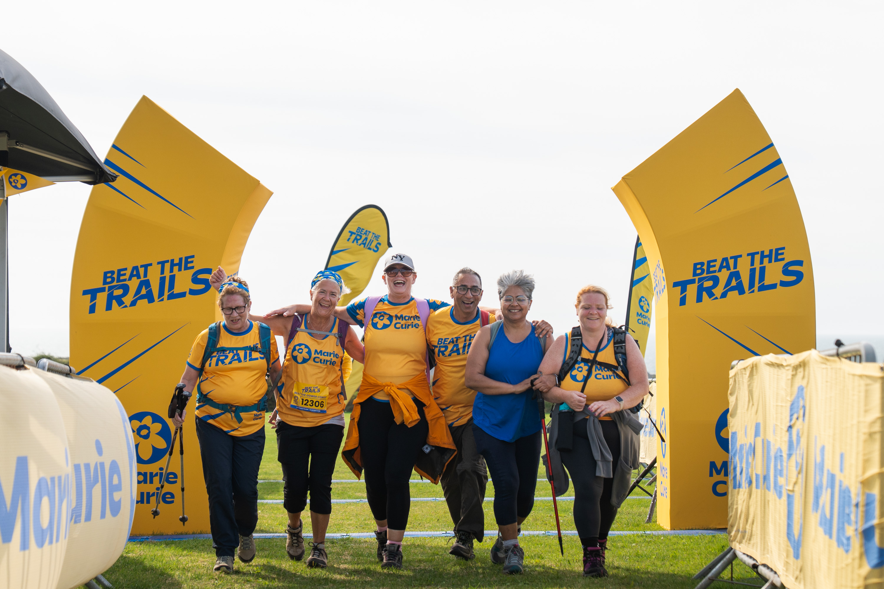 Group of trekkers are wearing yellow t-shirts and looking out at the scenery