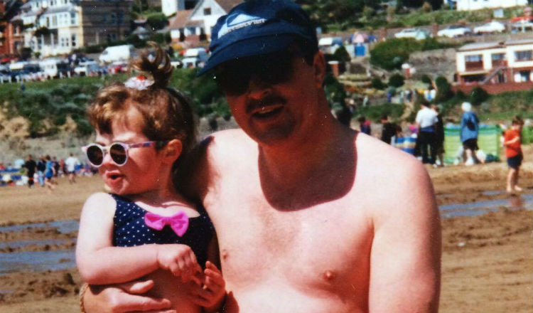 Jet as a child on a beach with her dad