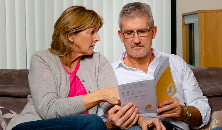 A Marie Curie Nurse giving and elderly couple advice