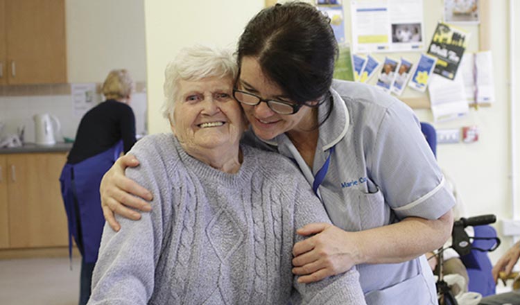 A nurse helping a lady to walk